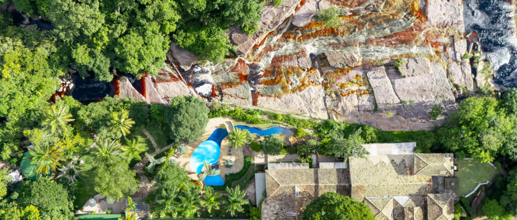 Cachoeiras do Rio Lençóis com o Hotel Canto das Águas ao fundo, em Lençóis, Chapada Diamantina.