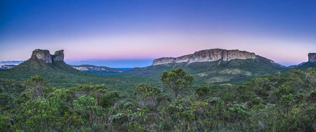 Céu violeta após o pôr do sol sobre os Gerais do Camelo, com vegetação de cerrado na Chapada Diamantina.