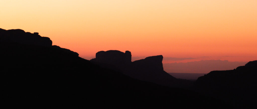 Silhueta do Morro do Pai Inácio diante de um pôr do sol laranja na Chapada Diamantina.